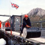 John Dudeney helps roll fuel drums to the base during the annual relief at Bird Island