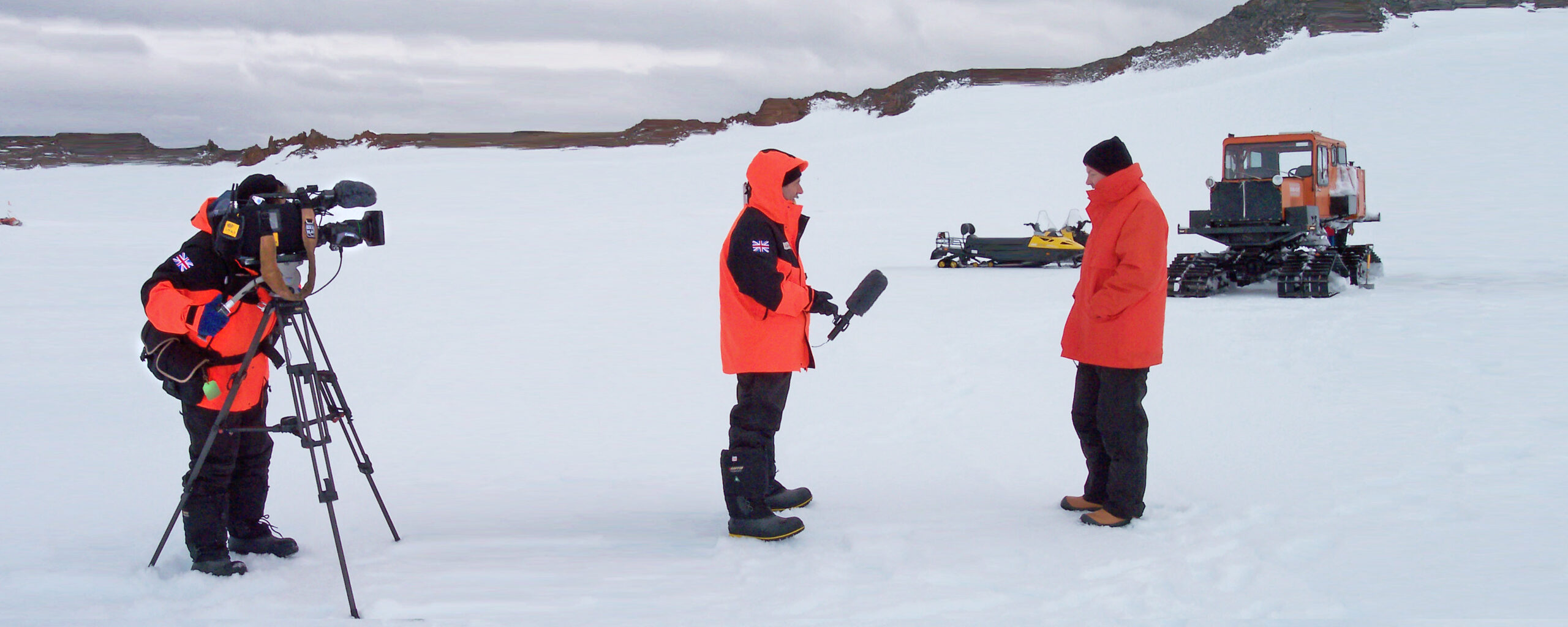 A film crew interviewing a man in an icy landscape