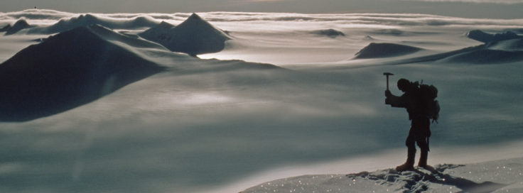 Geologist working on a rock outcrop on the Black Coast, Antarctica