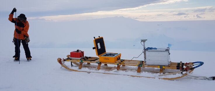 A scientist with a sled containing GPS and Radar equipment