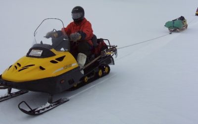 Two-person skidoo team roped together for safe field travel.