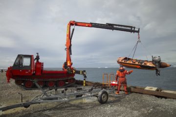 Inflatable boat being lowered into the water at Rothera's wharf. Boat transport allows both marine and terrestrial biologists to investigate sites further from the Station.
