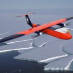 A plane flying over a body of water.