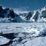 A person riding a snowboard down a snow covered slope.