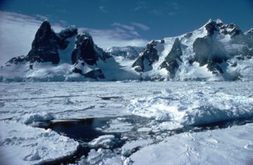 A person riding a snowboard down a snow covered slope.