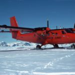 A plane flying over a body of water.