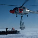 A helicopter flying over a body of water.
