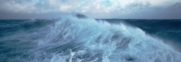 A man riding a wave on top of a body of water.