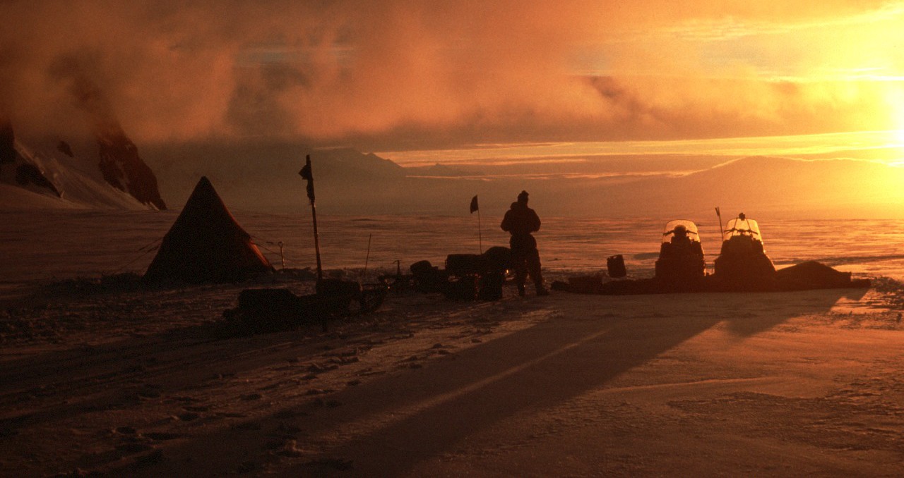 A group of clouds with a sunset in the background