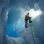British Antarctic Survey field assistant Rob Smith enters a crevasse alongside Reptile Ridge on Adelaide Island, Antarctica