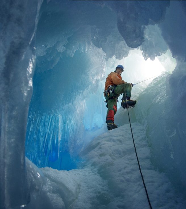 British Antarctic Survey field assistant Rob Smith enters a crevasse alongside Reptile Ridge on Adelaide Island, Antarctica