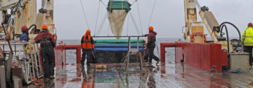 A group of people on a boat in the rain.