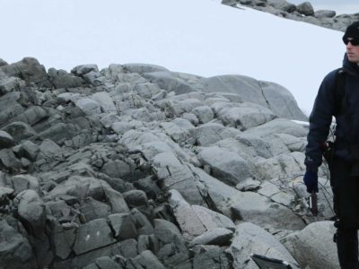 A man standing on a rock in the snow.