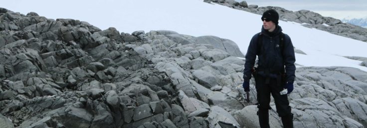 A man standing on a rock in the snow.