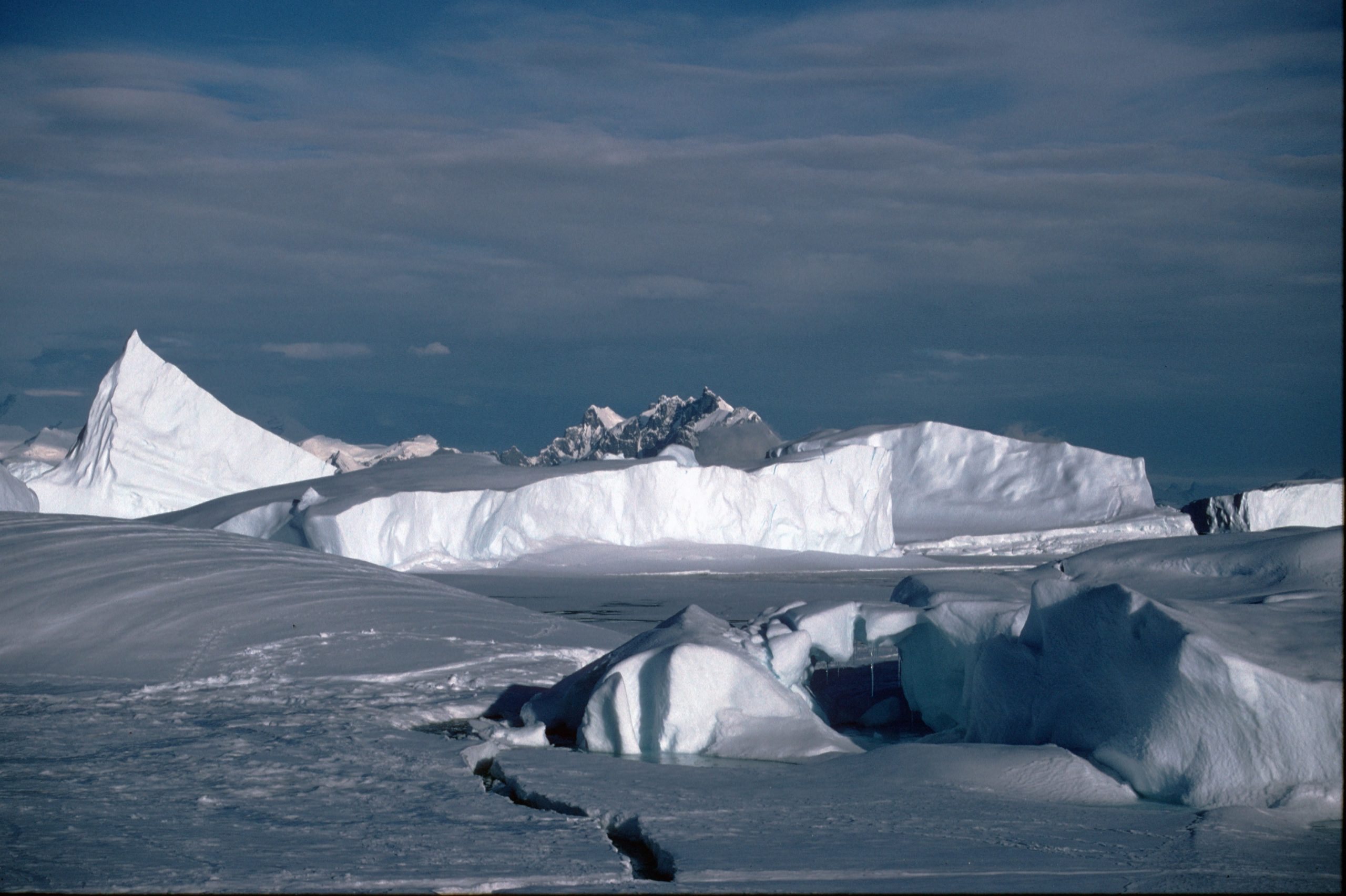 A person riding a snowboard down a snow covered mountain.