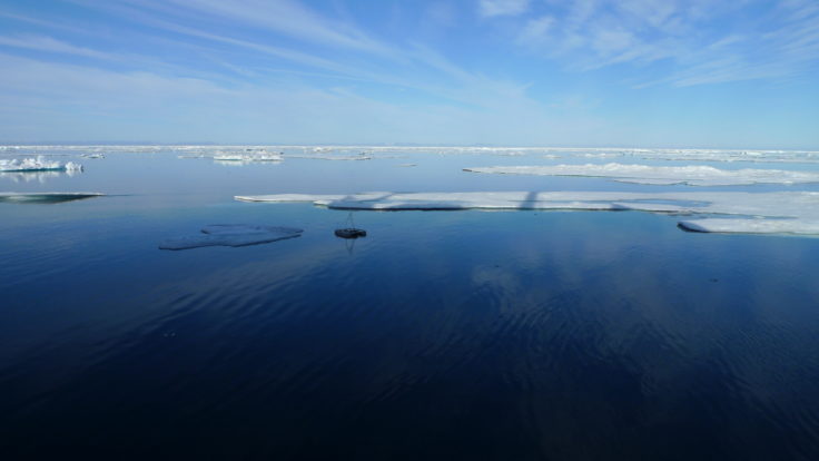 A group of clouds in the sky over a body of water.