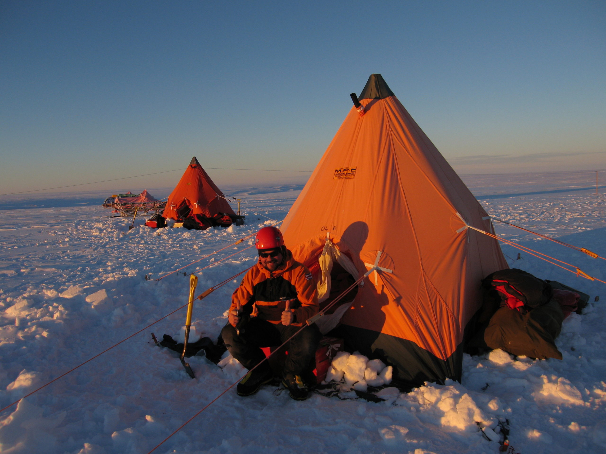 A tent with people in the snow.