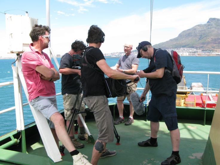 BBC film crew working with Peter Gibbs aboard the RRS Ernest Shackleton as the ship departs Cape Town