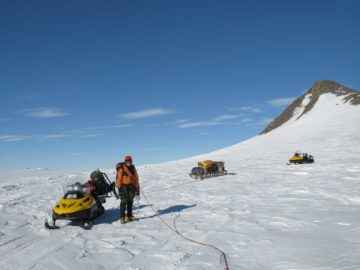 A group of people riding skis on top of a snow covered slope.