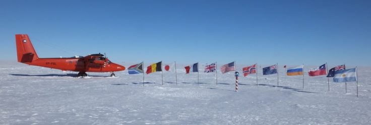 Survey aircraft VP-FBL enjoying her photo shoot at the ceremonial South Pole with the flags of all the original Antarctic Treaty nations