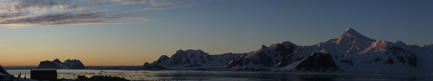 A sunset over a body of water with a mountain in the background.