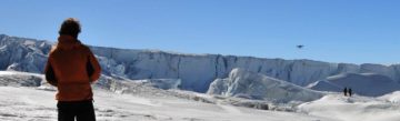A man walking across a snow covered mountain.