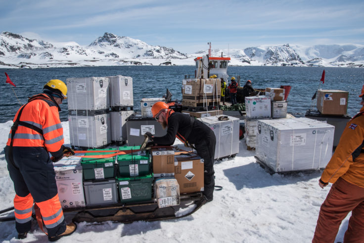 JCR staff unload the cargo tender and re-load cargo onto sledges to be hauled by ski-doo to the station 