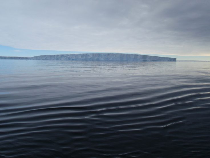 A large body of water in front of ice shelf