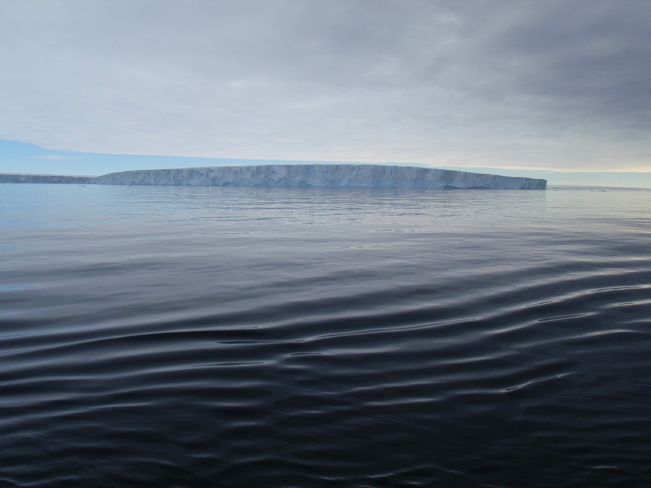 A large body of water in front of ice shelf