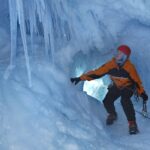 A man riding a snowboard down a snow covered slope.