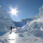 A man riding skis down a snow covered mountain.