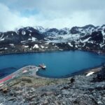 A body of water with a mountain in the background.