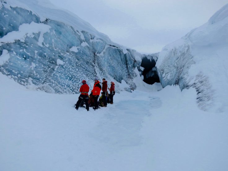 Glaciologists Jayne Kamintzis, Stephen Jennings, and Phil Porter and BAS field guide Catrin Thomas at the mouth of the meltwater channel in the Austre Brøggerbreen glacier on Svalbard. 