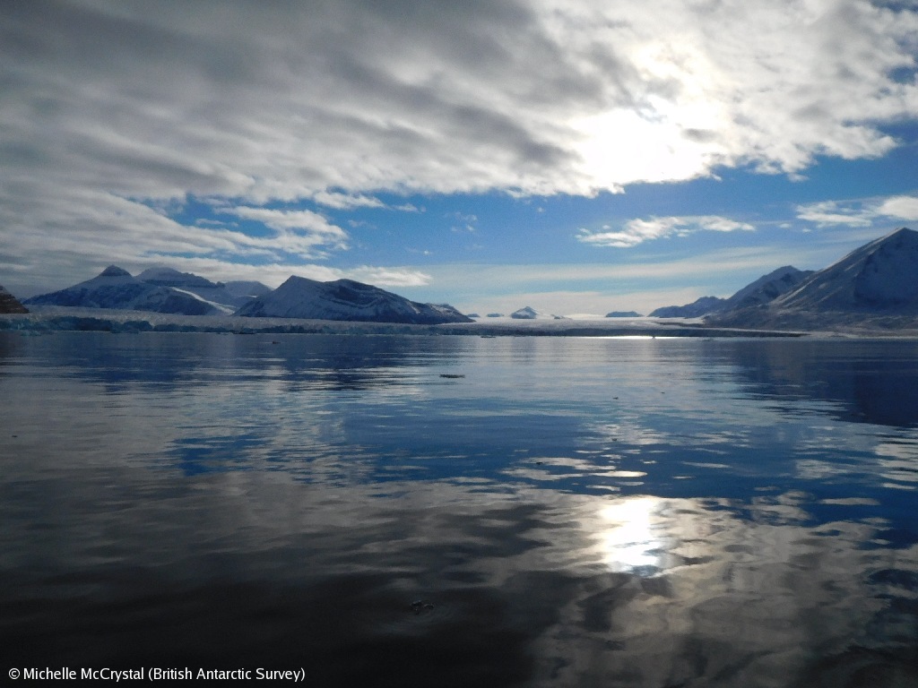 A body of water with a mountain in the background.