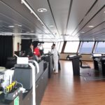 Panoramic view of the RRS Sir David Attenborough's Bridge - a large room with panoramic windows and control desks