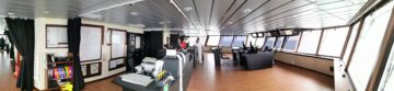 Panoramic view of the RRS Sir David Attenborough's Bridge - a large room with panoramic windows and control desks