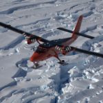 A aeroplace flying over a snowy landscape