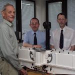 A group of people standing in front of a mirror posing for the camera.