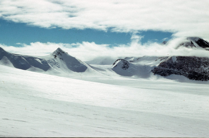 A man riding skis down a snow covered mountain.