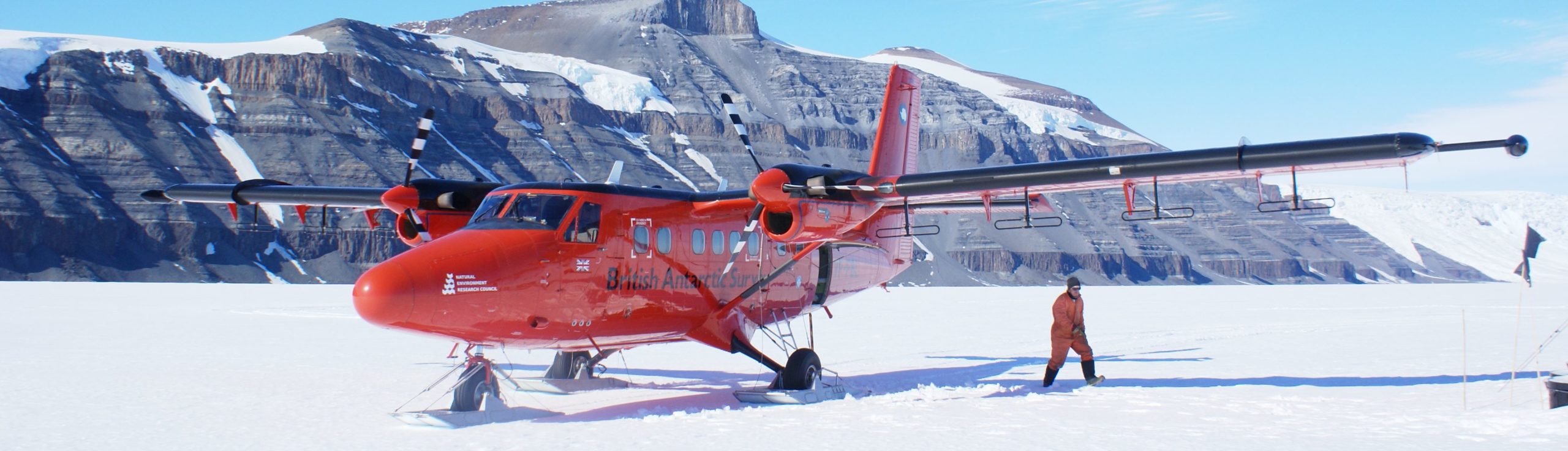 A airplane that is on top of a snow covered mountain.