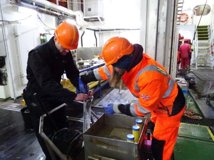 A man standing next to an orange.