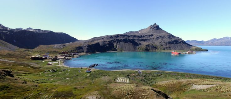 A body of water with a mountain in the background.