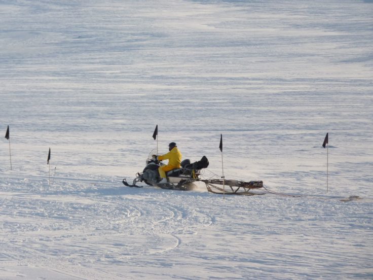 A group of people riding skis on top of a snow covered slope.
