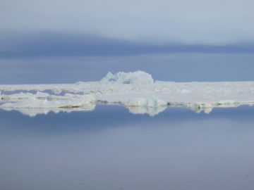 A group of clouds in the sky over a body of water.