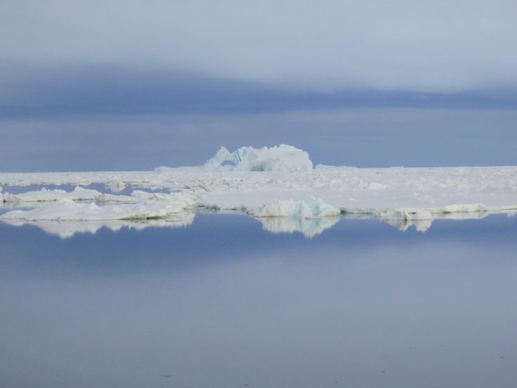 A group of clouds in the sky over a body of water.