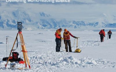 Scientists surveying the ground in an icy landscape with mountians in the background