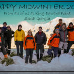 A group of people posing for a picture in the snow.