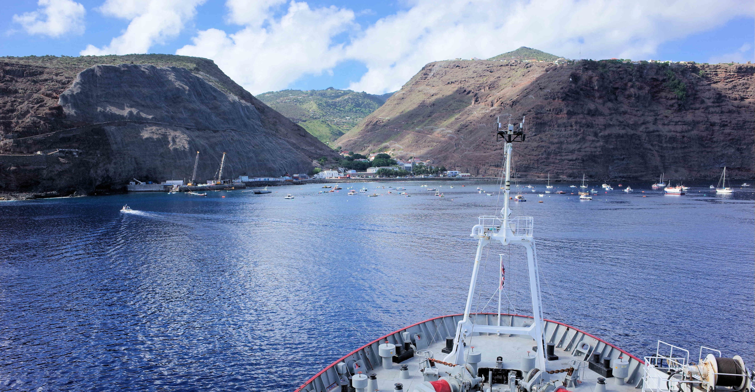 A large boat in a body of water with a mountain in the background.