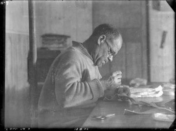 Lt. Cdr. James Marr at work mending webbing, Bransfield House, Port Lockroy, 18th June 1944. Photographer: I M Lamb. Archive ref: AD6/19/1/A7