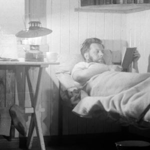 A man sitting on a chair in front of a mirror.